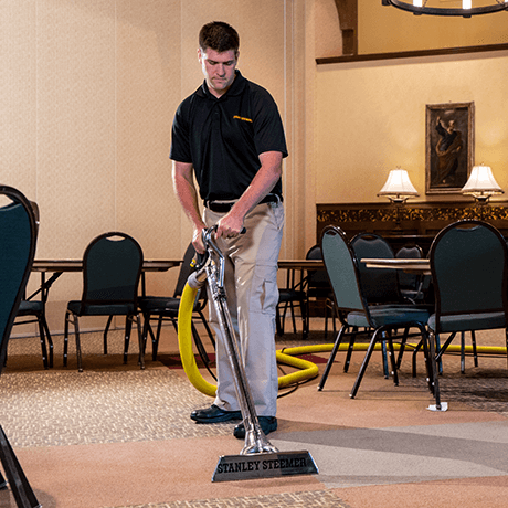 Stanley Steemer technician cleaning carpet in banquet hall Stanley Steemer technician cleaning carpet in banquet hall