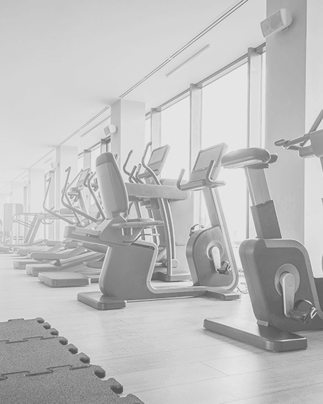 Fitness room with workout bikes, gym mat, and hardwood floors Fitness room with workout bikes, gym mat, and hardwood floors
