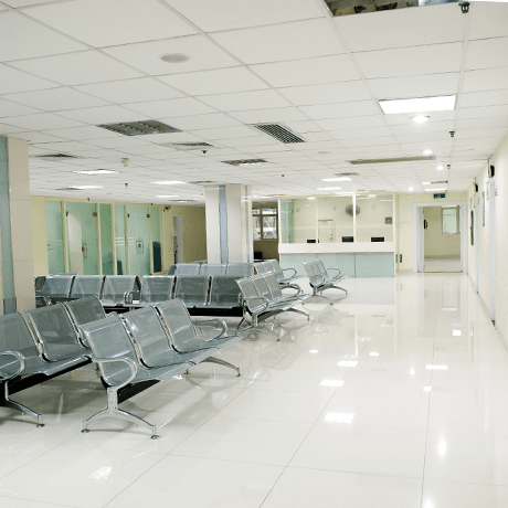 Waiting room inside hospital with white tile floors Waiting room inside hospital with white tile floors
