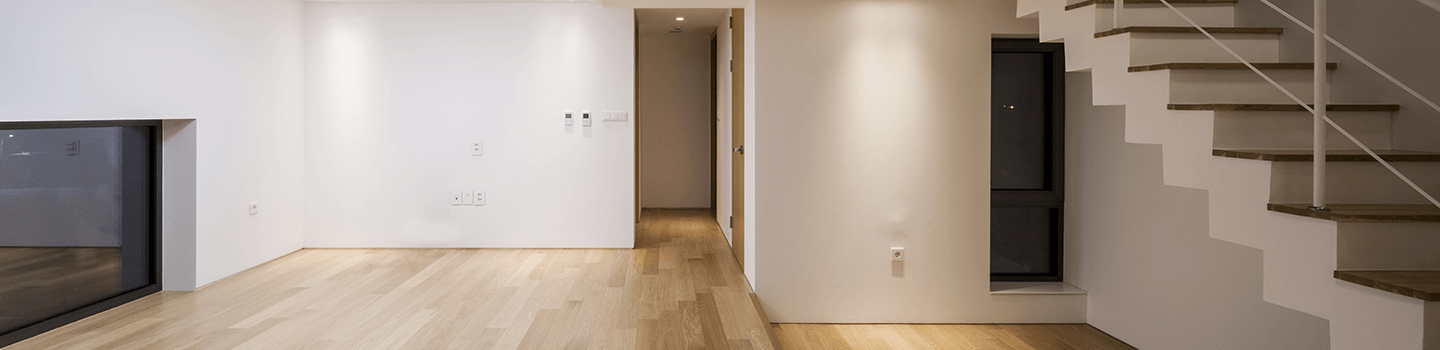 Empty apartment with stairs, hardwood floors, and white walls