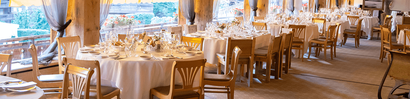 Round tables and chairs near windows in restaurant