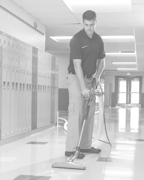 Stanley Steemer technician cleaning VCT floors in school hallway Stanley Steemer technician cleaning VCT floors in school hallway