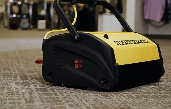 A counter rotating brush machine being used to clean a retail store carpet