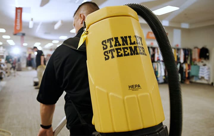 A counter rotating brush machine being used to clean a retail store carpet
