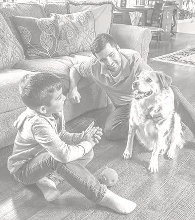 Hardwood-Floor-Cleaning-Family-and-Dog-on-Hardwoods Father and son sitting on hardwood floors with their dog.