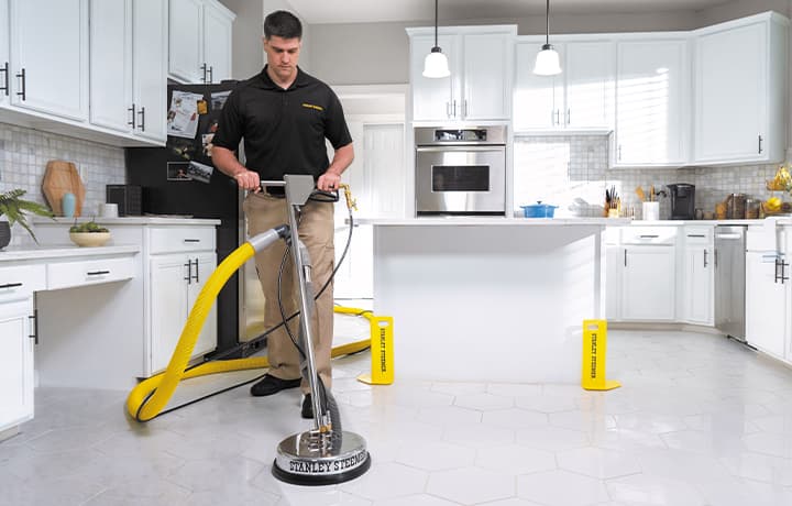 Technician cleaning tile and grout on a house for sale
