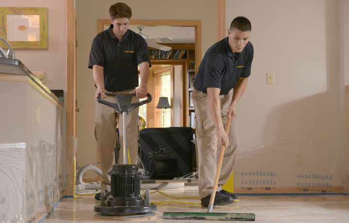 Stanley Steemer technicians spring cleaning natural stone floor in home