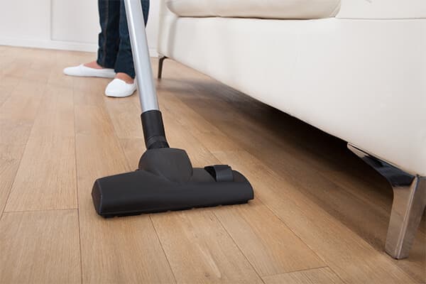 black vacuum against hardwood floor