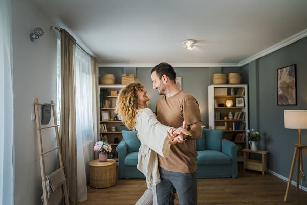 couple dancing in living room with soft lighting