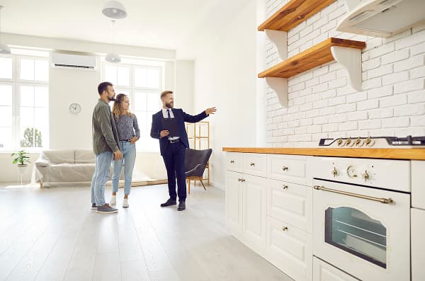 couple touring a kitchen with light shining in