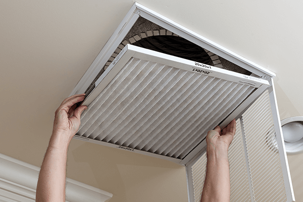 HEPA Filter Dust Mite Blog Image person replacing the HEPA filter in the ceiling