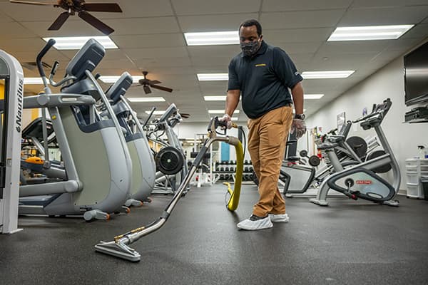 Technician-cleaning-gym Technician professionally cleaning gym floors