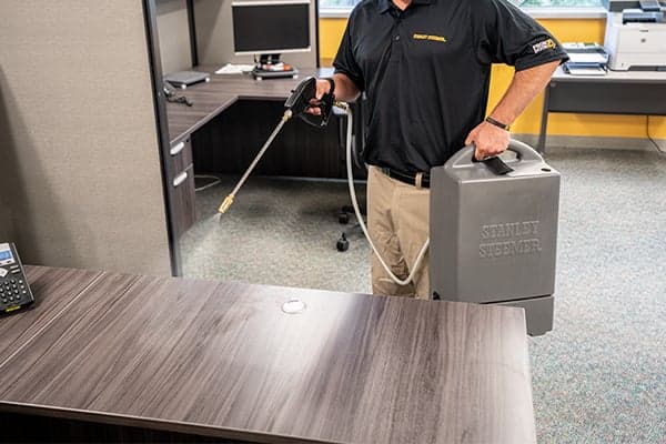 Technician-disinfecting-desks Technician disinfecting desk