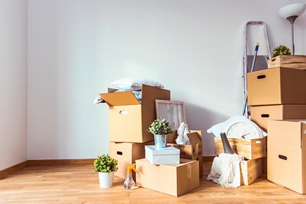 Moving Boxes moving boxes in empty room with white walls and hardwood floor
