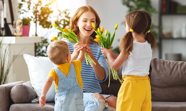 mom with red hair accepting flours from kids in spring
