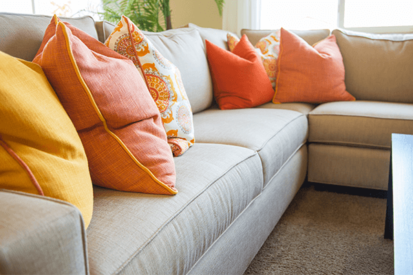 Gray couch with pillows Gray fabric sectional with yellow and orange throw pillows