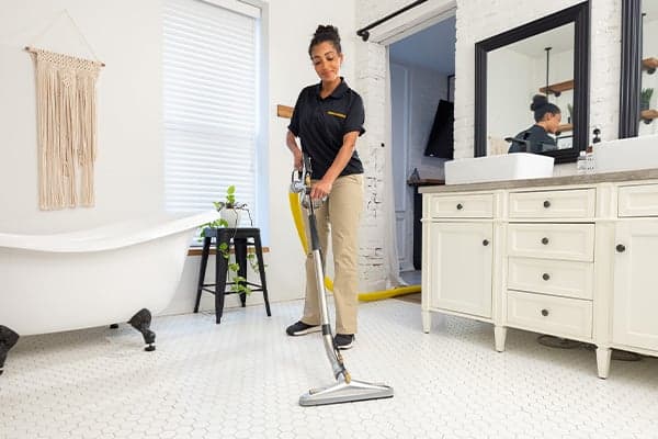 Tile and Grout Cleaning Photo Woman technician cleaning tile and grout in customer bathroom