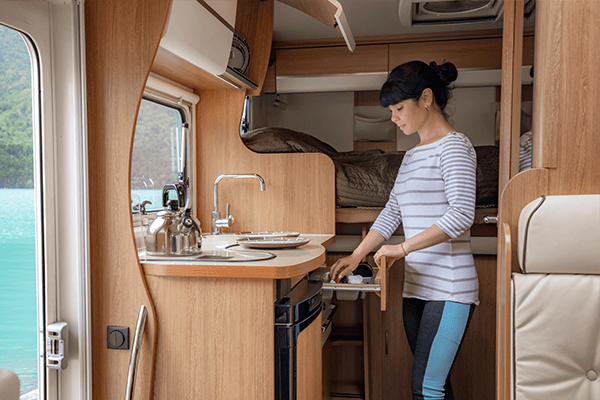 RV Kitchen Woman opening a drawer in a small RV kitchenette