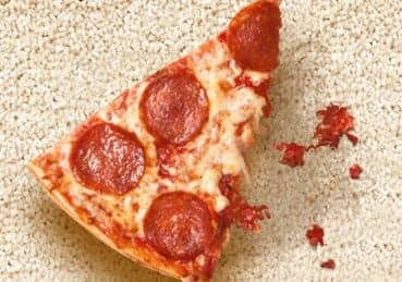 Removing-Grease-from-Carpet Pizza slice sitting on carpet with sauce stains.