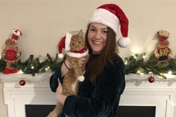 megan and rayne wearing santa hats in front of fireplace