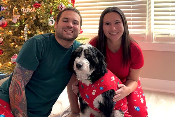 milo and family in front of christmas tree in christmas pjs
