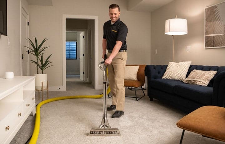 Stanley Steemer Technician Deep Cleaning Living Room Carpet Flooring Stanley Steemer technician deep cleaning living room carpet flooring